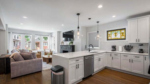 A modern kitchen with white cabinetry, a central island, and pendant lighting.
