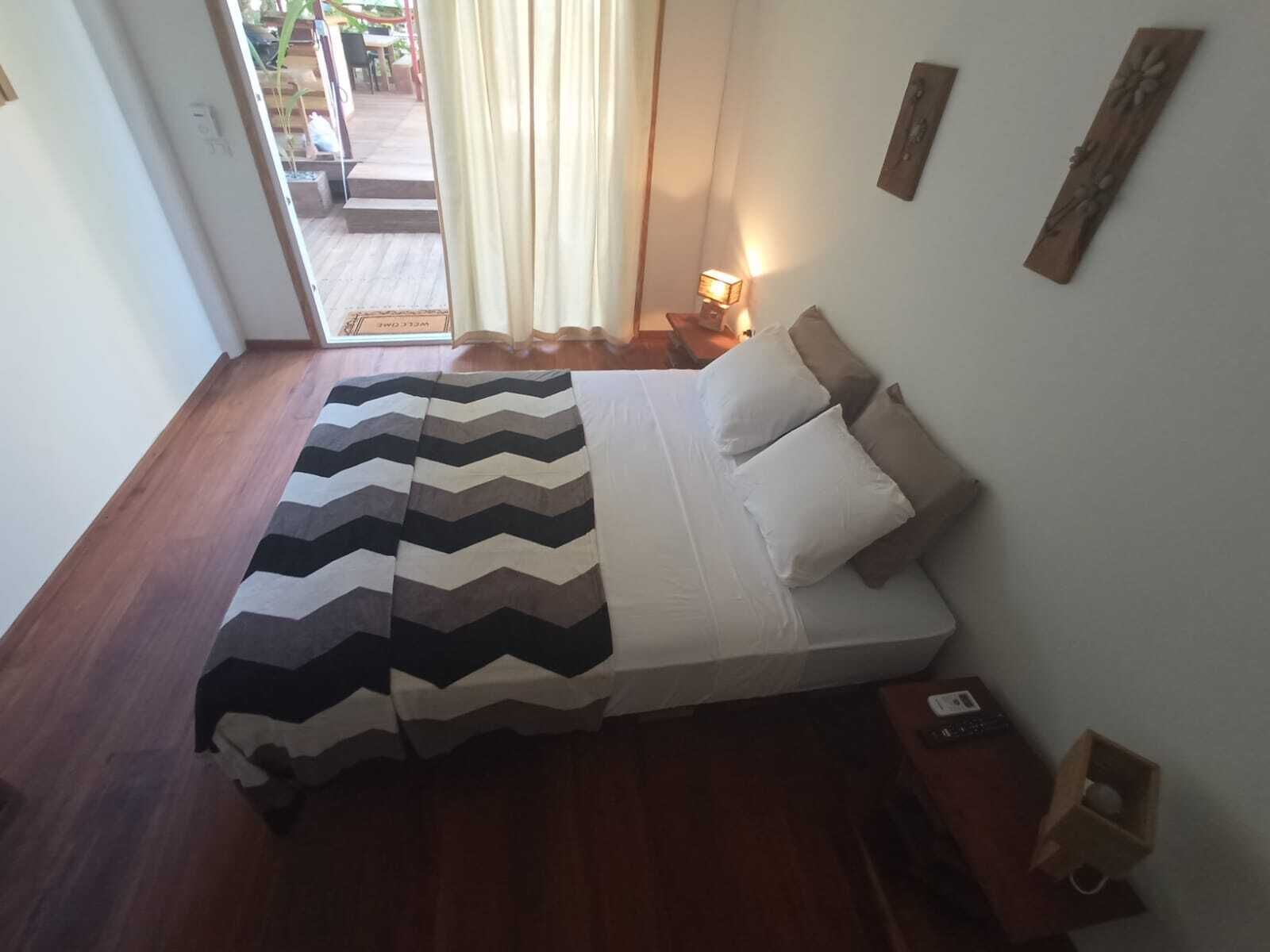 Un dormitorio con cama, mesita de noche y lámpara.