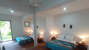 Habitación de hotel con dos camas, suelo de madera y lámparas de noche.