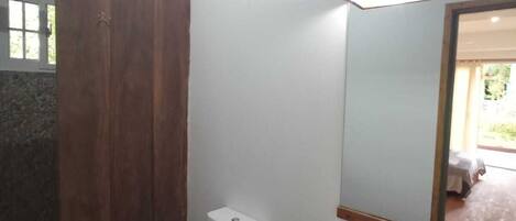 A bathroom with a toilet, sink, and wooden cabinet.