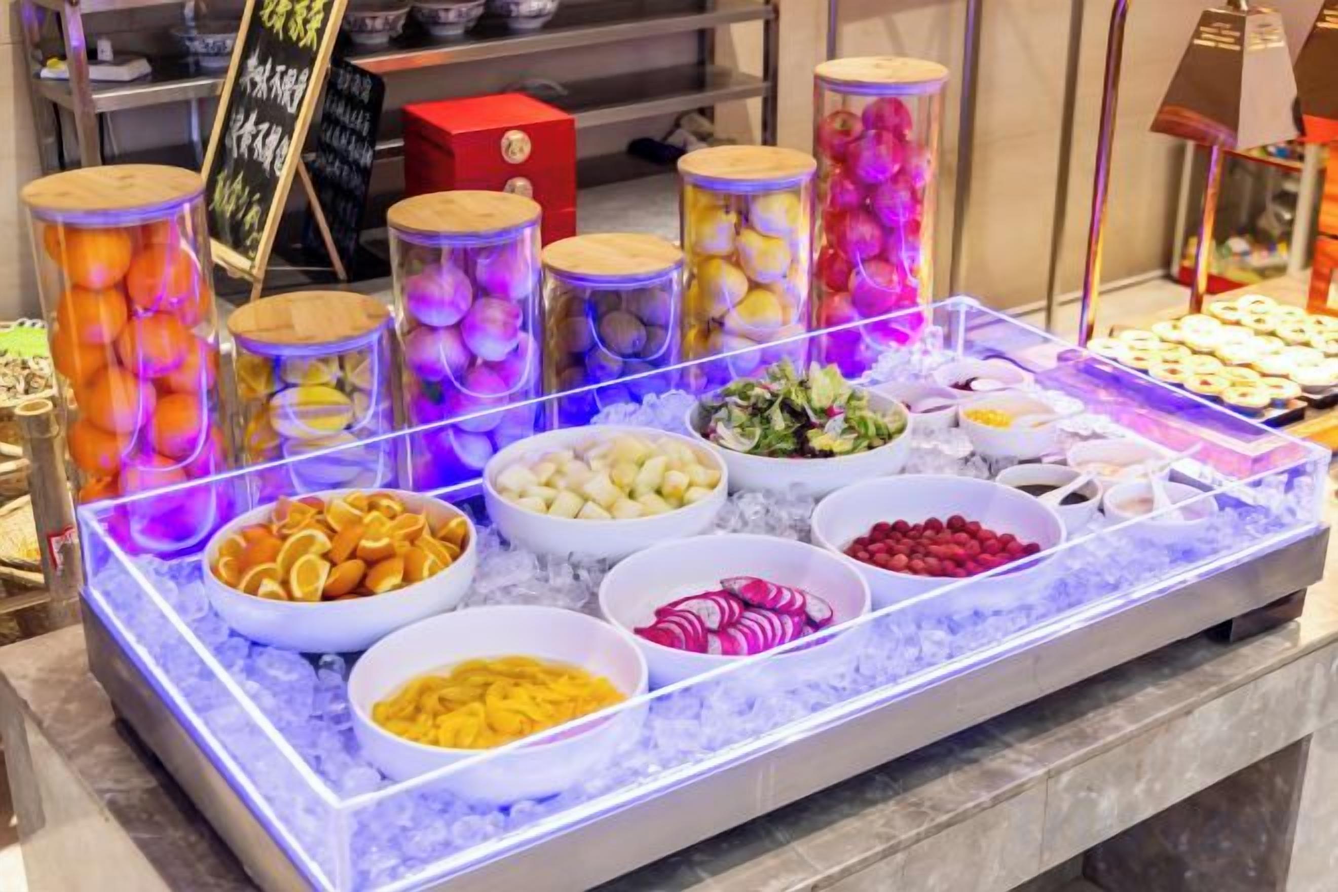 A buffet with various food items displayed on a table with a glass top.