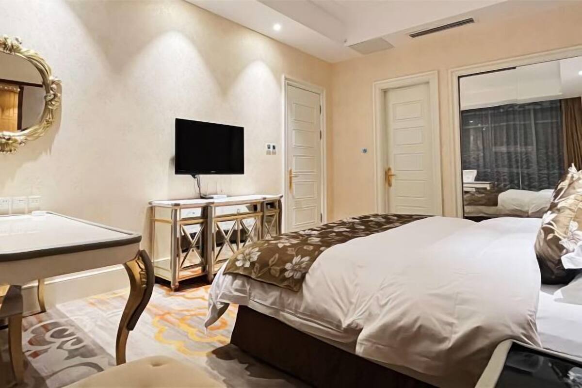 Une chambre d  ’hôtel avec un lit, un bureau, une télévision et une grande fenêtre.