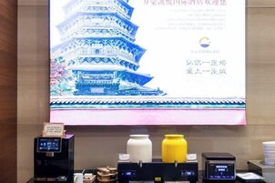 A projection of a traditional Chinese pagoda on a wall, a digital clock, and a coffee machine.