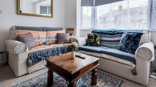 A living room with a sofa, a coffee table, and a window with a view.