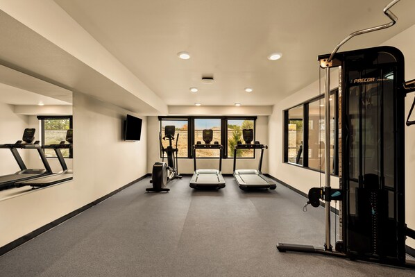 A gym with treadmills, elliptical machines, and a weightlifting area. - LivAway Suites Tri-Cities- Richland (Richland)
