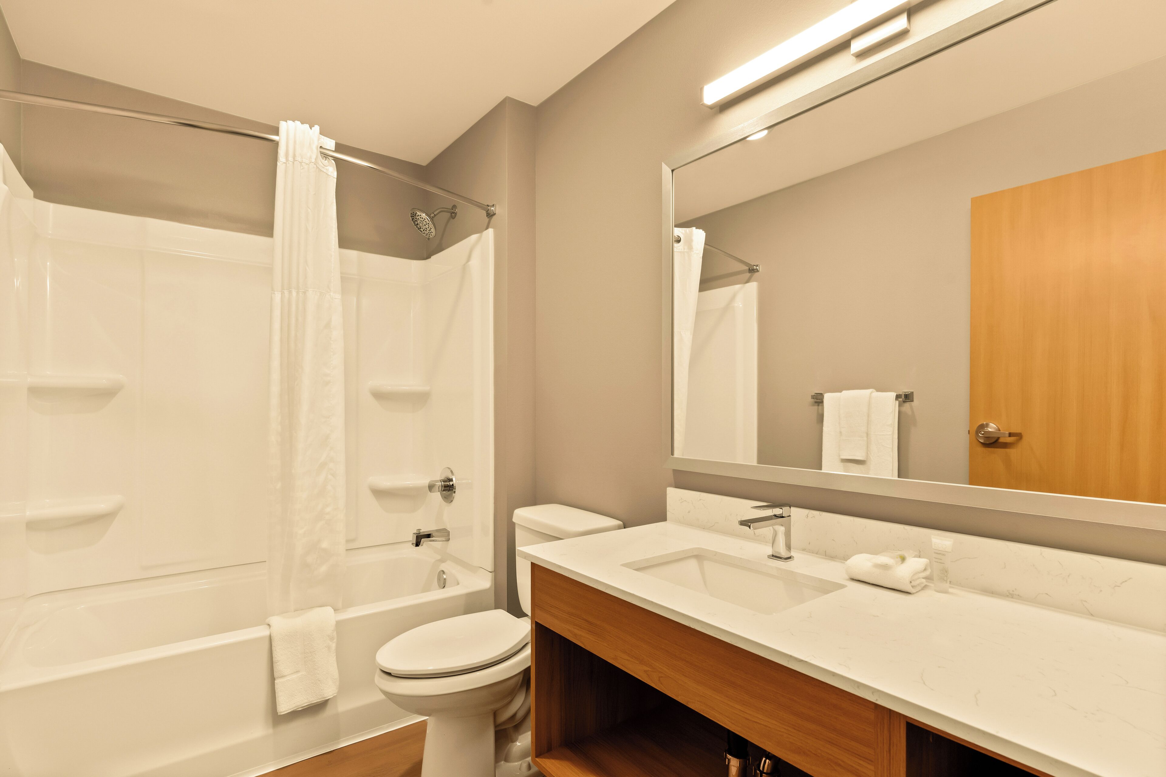 A modern bathroom with a bathtub, toilet, and sink.