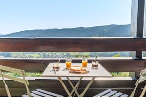 A wooden table with a glass of orange juice, two glasses of water, and a plate of toast.