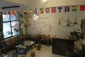 Ein möbliertes Wohnzimmer mit Sofa, Couchtisch und Zimmerpflanzen.