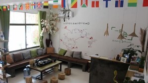 A cozy living room with a sofa, coffee table, and a map on the wall.
