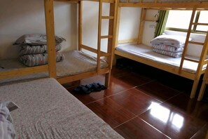 A room with two bunk beds, a small table, and a window with curtains. - Zhangjiajie Cloud Youth Hostel (Zhangjiajie)