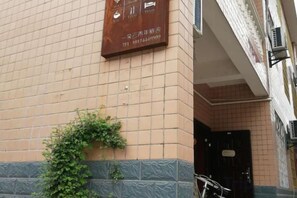 A building facade with a tiled entrance and a door. - Zhangjiajie Cloud Youth Hostel (Zhangjiajie)