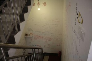 A staircase with hand-written notes on the walls, a metal railing, and a light fixture. - Zhangjiajie Cloud Youth Hostel (Zhangjiajie)