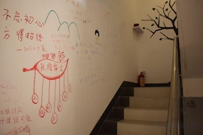 A staircase with a hand-drawn diagram on the wall and a tree decoration. - Zhangjiajie Cloud Youth Hostel (Zhangjiajie)