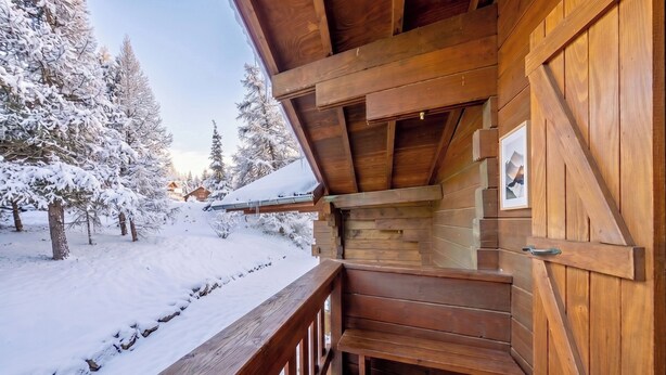 A wooden cabin with a wooden deck, snow-covered trees, and a clear sky. - Casa-Forêt Blanche, splendide chalet (Risoul)
