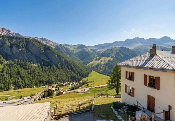 A mountain village with a prominent building featuring a sloped roof and wooden shutters. - Casa-La Fuste, centre Saint-Véran, ski au pied (Molines-en-Queyras)