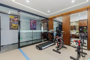 Ein modernes Fitnessstudio mit Cardiogeräten, einem Laufband und einem Spiegel.
