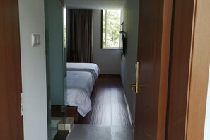 A hotel room with a bed, a window, a door, and a light switch. - Renyi Business Hotel (Ningbo)
