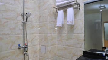 A bathroom with a shower, a sink, and a mirror.