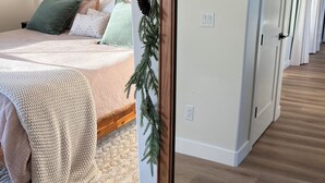 Une chambre à coucher avec un lit, une table de chevet et un téléviseur fixé au mur.