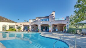 A swimming pool with a clear blue water, surrounded by lounge chairs and a building with arched doorways. - Sunny San Diego Condo w/ Pool Access Near Wineries (San Diego)