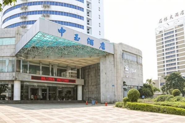 A modern building with a glass entrance and signage indicating it is a hotel.