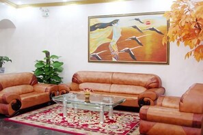 A living room with two brown sofas, a glass coffee table, and a patterned rug. - Zhongyu Hotel (Beihai)