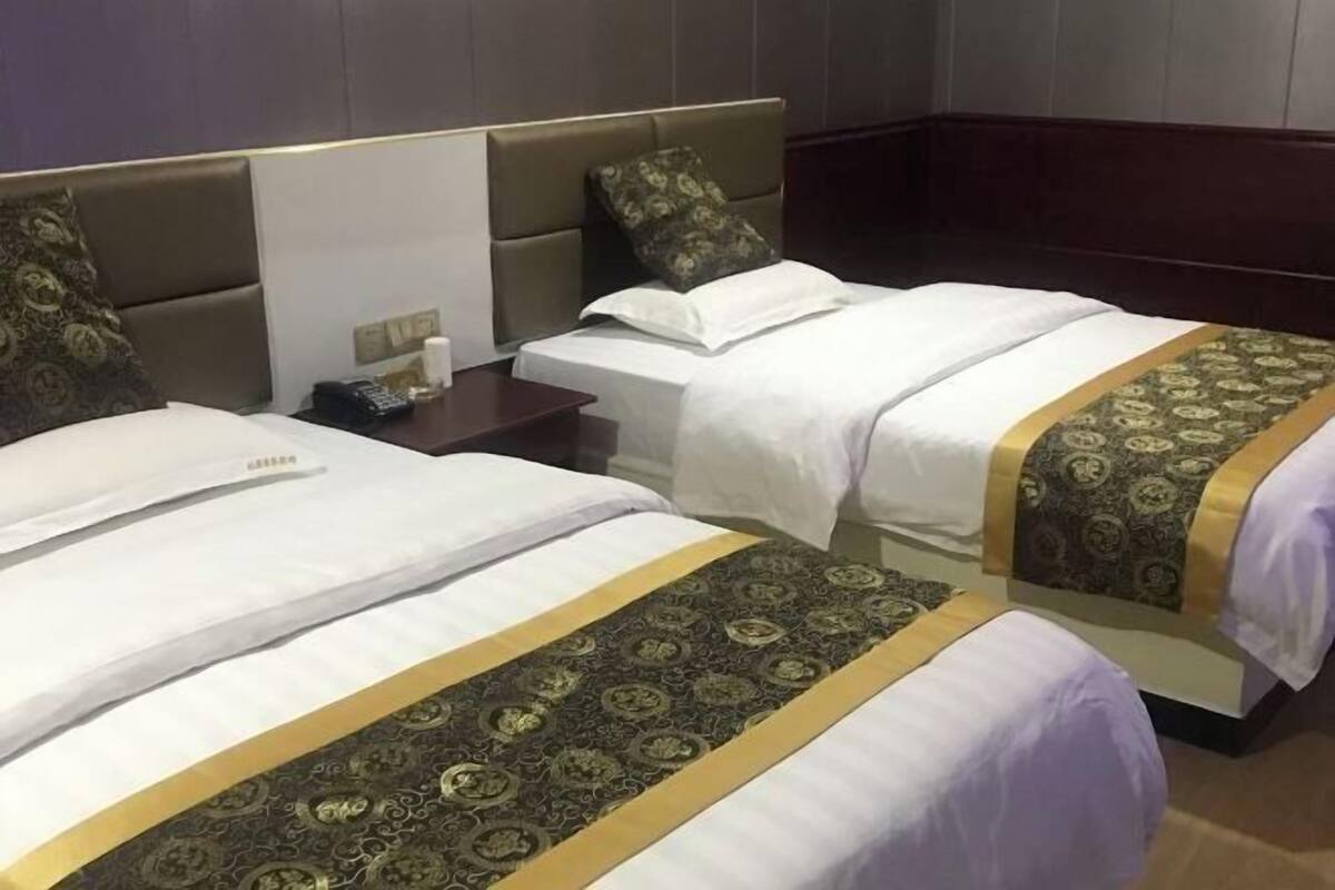 Une chambre d’hôtel avec deux lits, une table de chevet et une petite table.