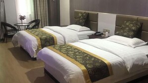 Habitació d'hotel amb dos llits, una taula petita amb seients i una taula de nit amb un telèfon.