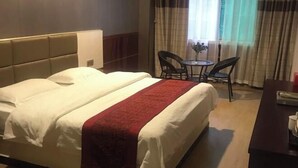 Una habitació d'hotel amb un llit, una taula de nit i una cadira.