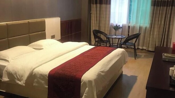 A hotel room with a bed, a desk, and a chair. - Chenzhou Wangquan Hotel (Chenzhou)