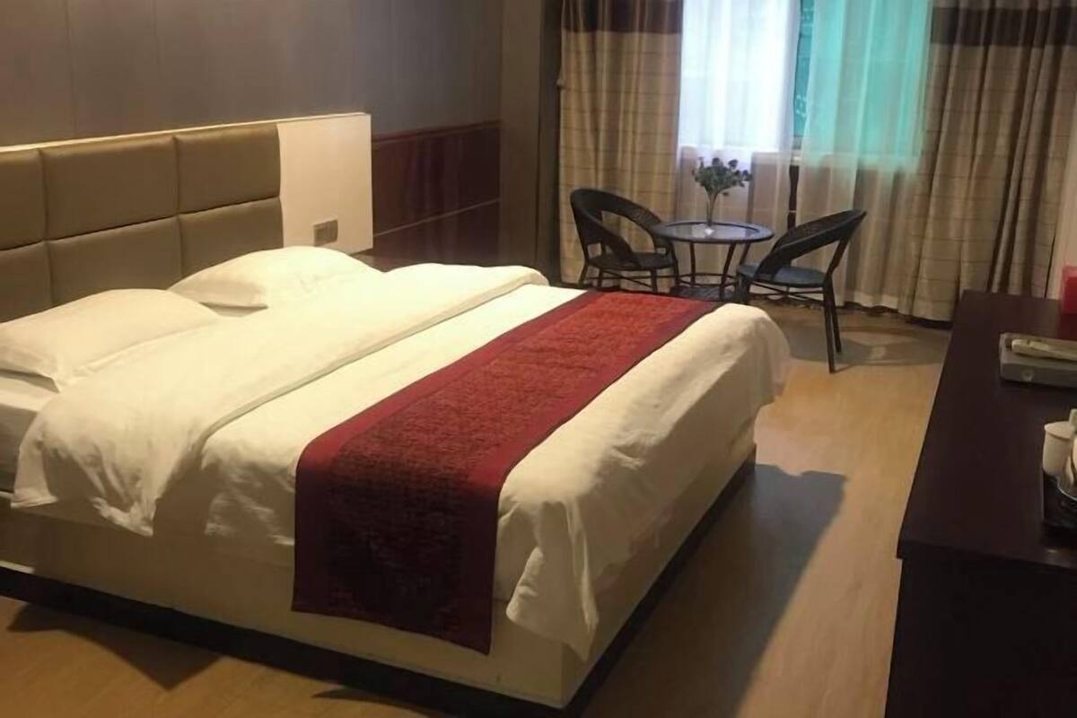 Une chambre d’hôtel avec un lit, un bureau et une chaise.