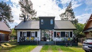 A two-story house with a paved driveway leading to the entrance. - Apartment in Jaroslawiec Near the Beach (Postomino)