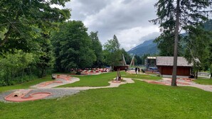 Un parque con una pista de atletismo, equipo de ejercicio y un edificio pequeño.