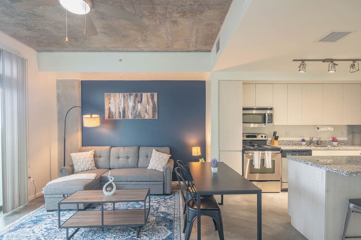 City appartement, 1 queensize bed met slaapbank | Woonruimte | Een 55-inch smart-tv met digitale zenders