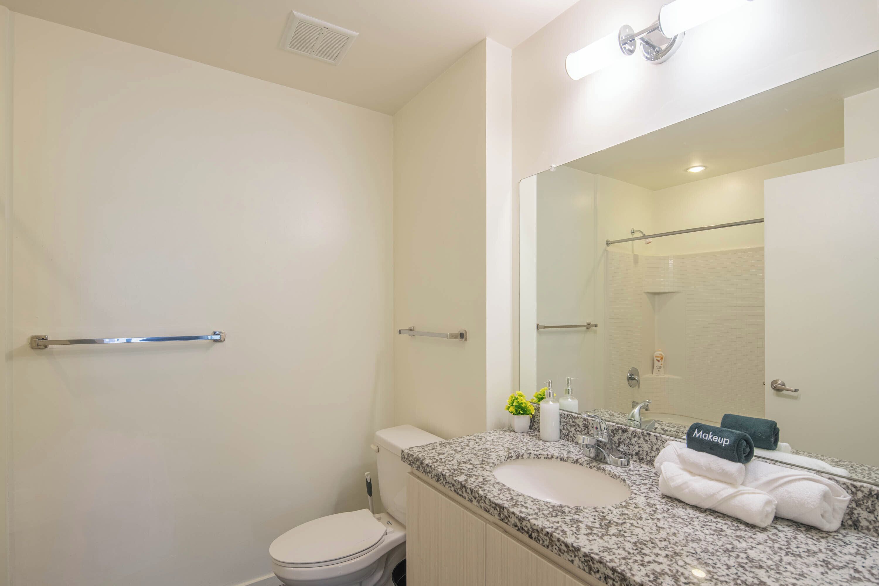 A modern bathroom with a toilet, sink, and shower.