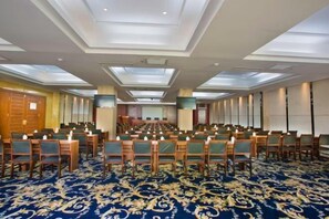 A conference room with rows of chairs, a patterned carpet, and a ceiling with recessed lighting. - Zhongheng Zangji Xima Hotel (Nyingchi)
