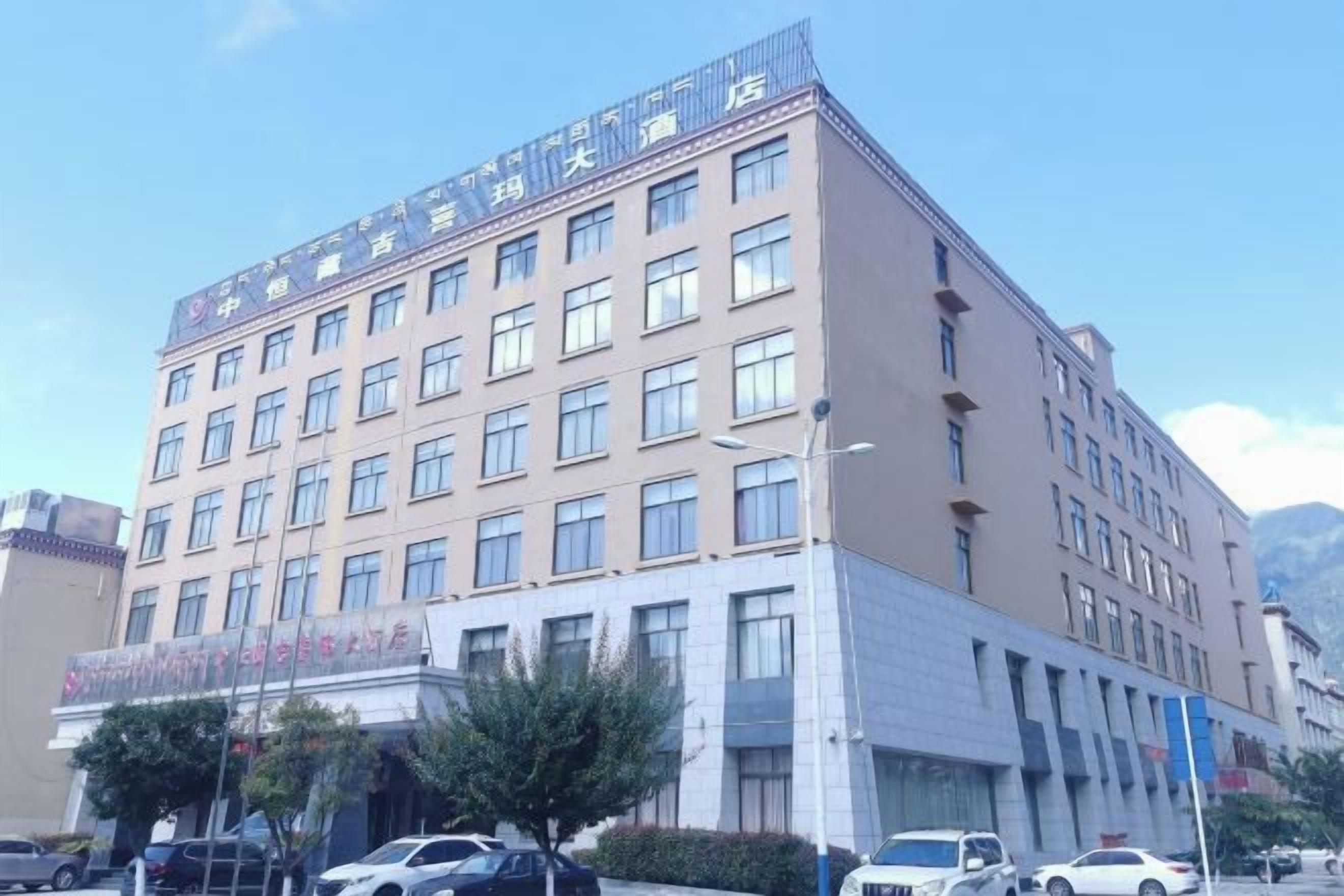Un hotel de varios pisos con fachada plana, ventanas amplias y una entrada visible con señalización.