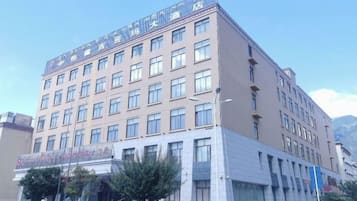 Un hotel de varios pisos con fachada plana, ventanas amplias y una entrada visible con señalización.