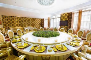 Un comedor formal con una mesa redonda, sillas y un arreglo floral en el centro.