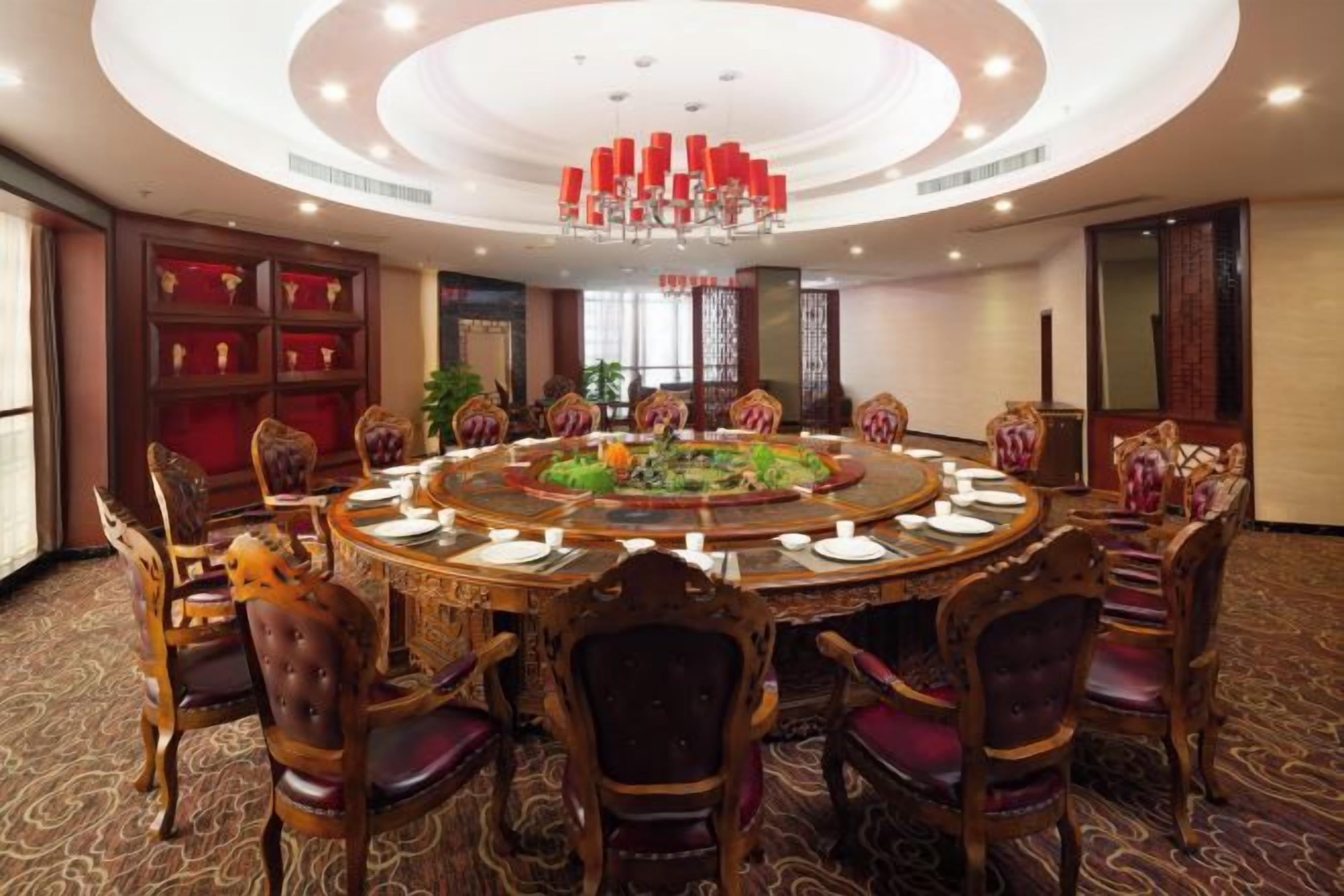 A conference room with a round table, chairs, and a chandelier.