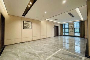 A spacious hallway with a polished marble floor, framed artwork on the walls, and a door at the end. - Dongjiang International Hotel (Foshan)