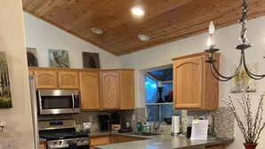 Una cocina moderna con armarios de madera, electrodomésticos de acero inoxidable y una isla central con asientos.