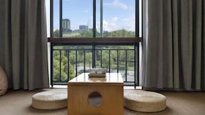 A room with a large window, a wooden table, and two round cushions. - Penguin Aurora City Hotel (Linhai Chonghemen) (Linhai)