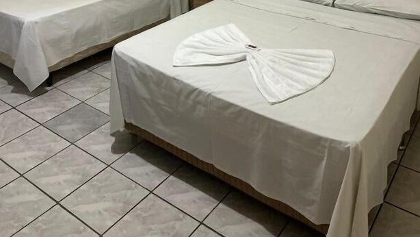A hotel room with two single beds and one double bed, all with white linens. - Bravo Inn hotel Coxim (Coxim)