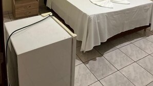 A single bed with a wooden headboard and a small bedside table with a patterned cushion. - Bravo Inn hotel Coxim (Coxim)
