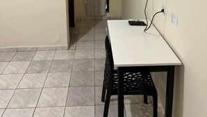 A small room with a white table and black chairs, a mounted TV on the wall, and an air conditioning unit above the door. - Bravo Inn hotel Coxim (Coxim)