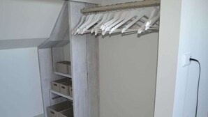 Un vestidor con repisas de madera y barra para colgar ropa.