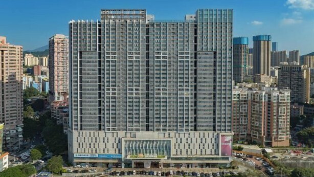 A high-rise building with a modern architectural design, featuring a prominent entrance with a glass facade and a series of balconies. - Kaisa Keyu Hotel (Shenzhen East Railway Station Buji Subway Station) (Shenzhen)