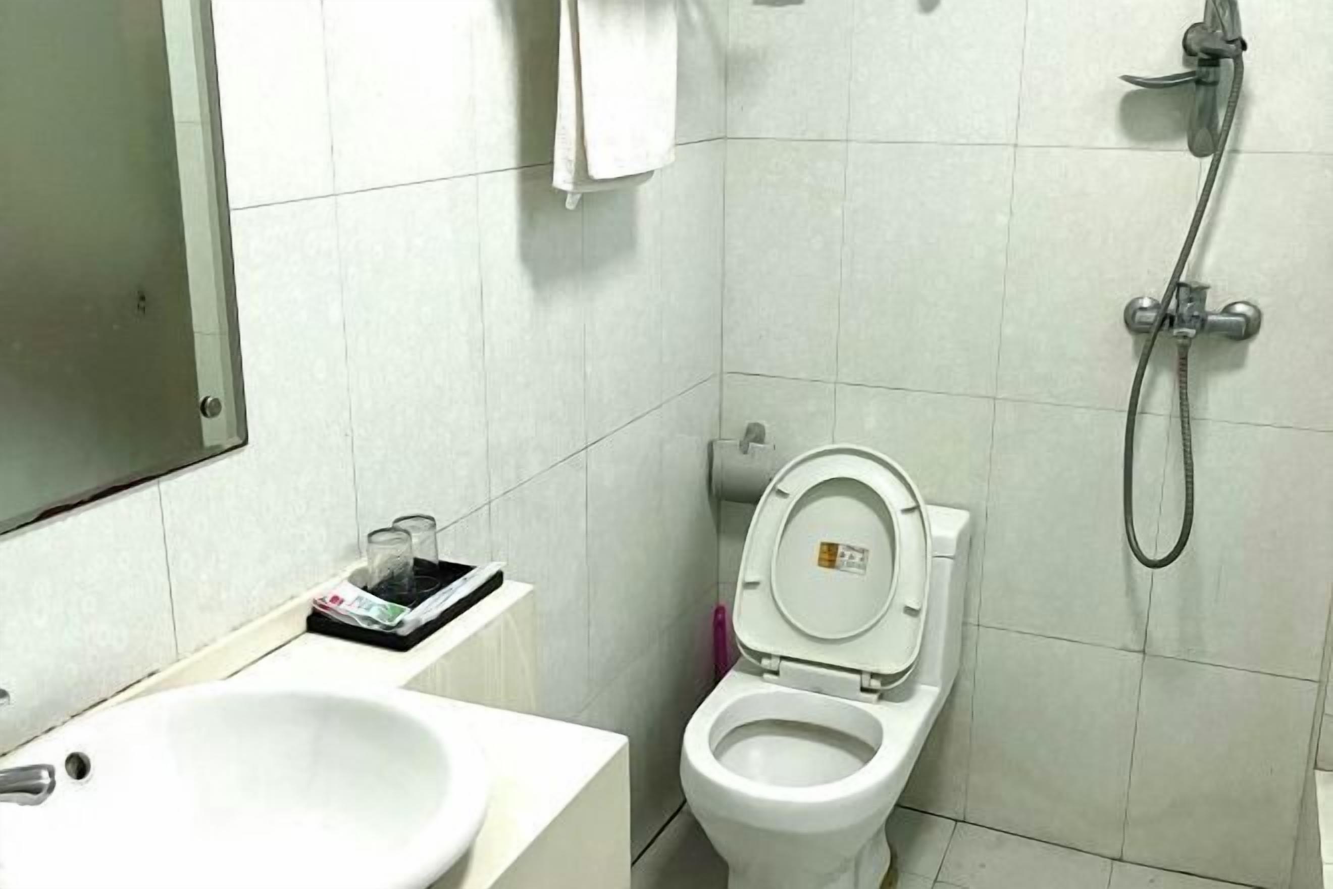 Un baño con lavamanos, inodoro y ducha blancos.