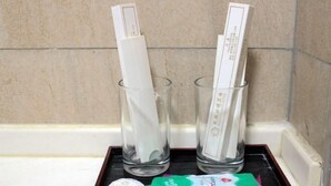 Dos vasos transparentes con servilletas blancas sobre una bandeja.